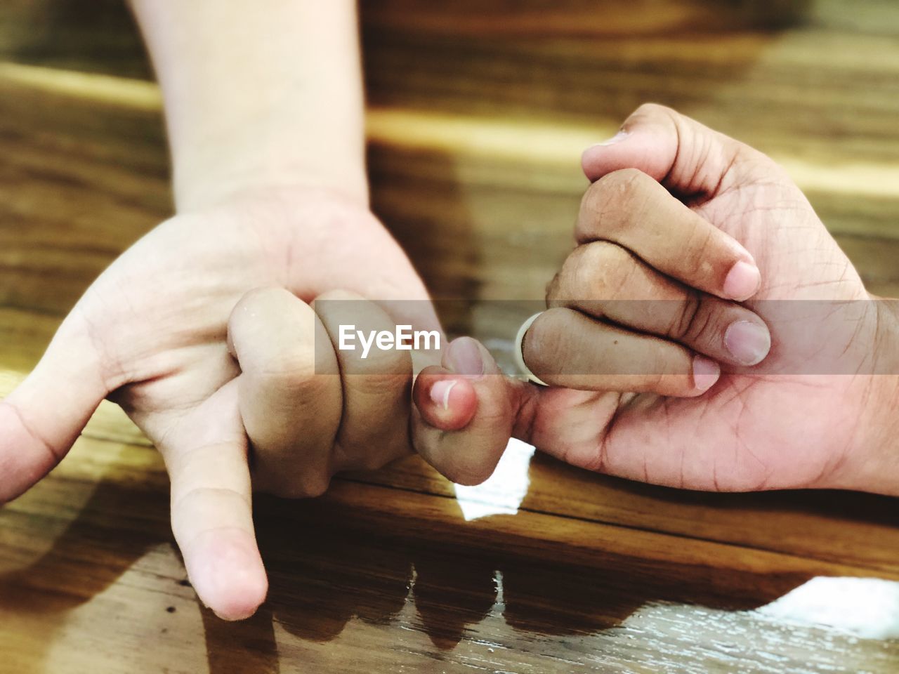 Cropped image of people holding hands on table