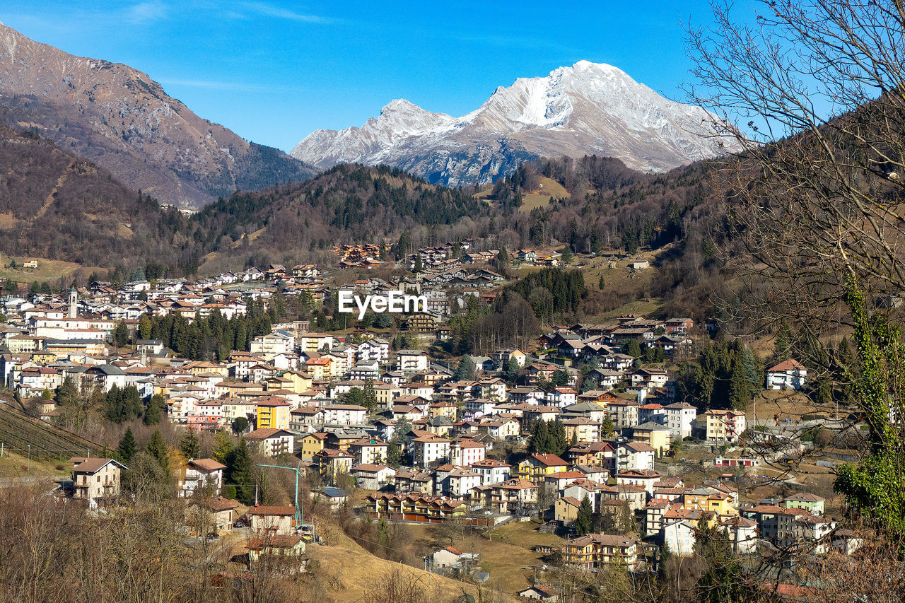 AERIAL VIEW OF TOWNSCAPE AGAINST MOUNTAIN