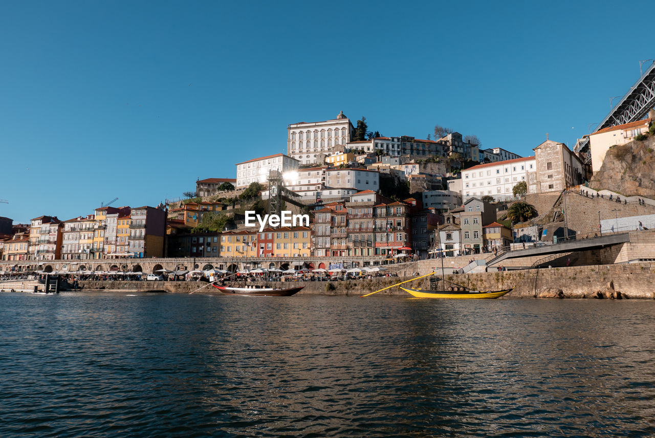 RIVER BY BUILDINGS AGAINST CLEAR SKY