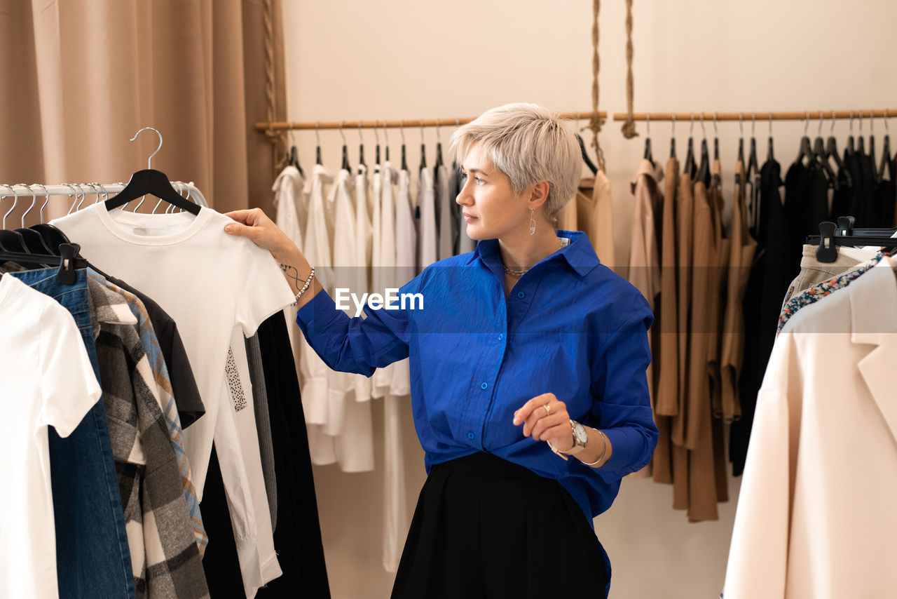 Woman choosing dress at clothing store
