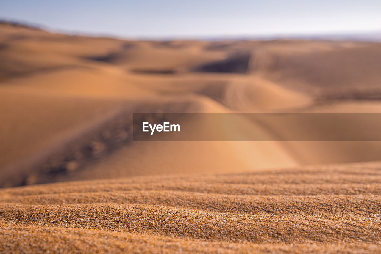 Beautiful shiny brown sand with natural waves pattern on sunny day