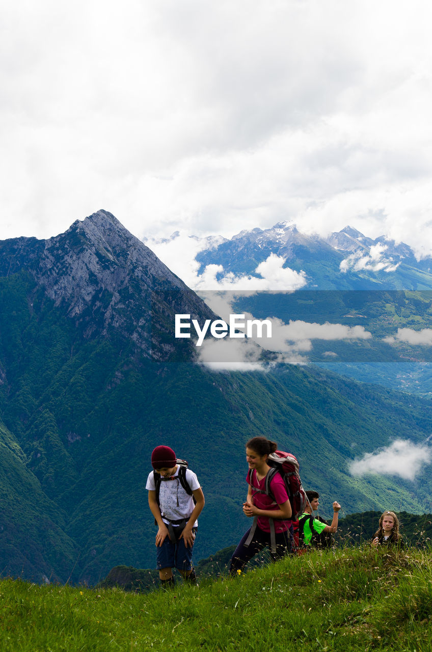 PEOPLE ON MOUNTAINS AGAINST SKY