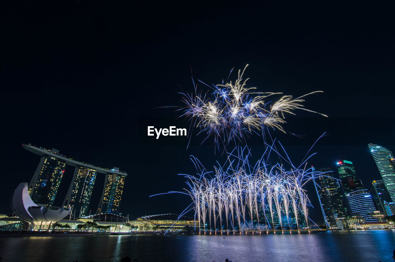 Firework display over river at night