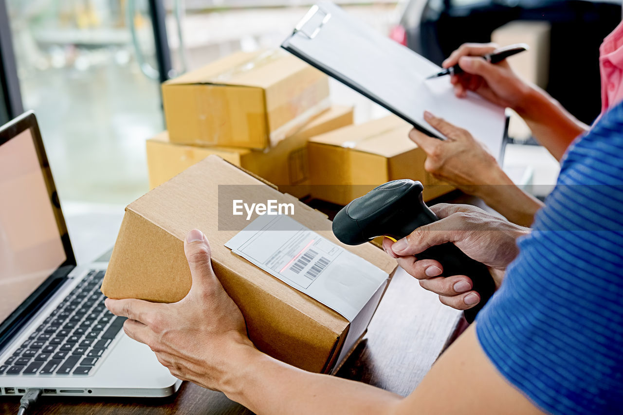 Cropped hand of entrepreneur scanning boxes 