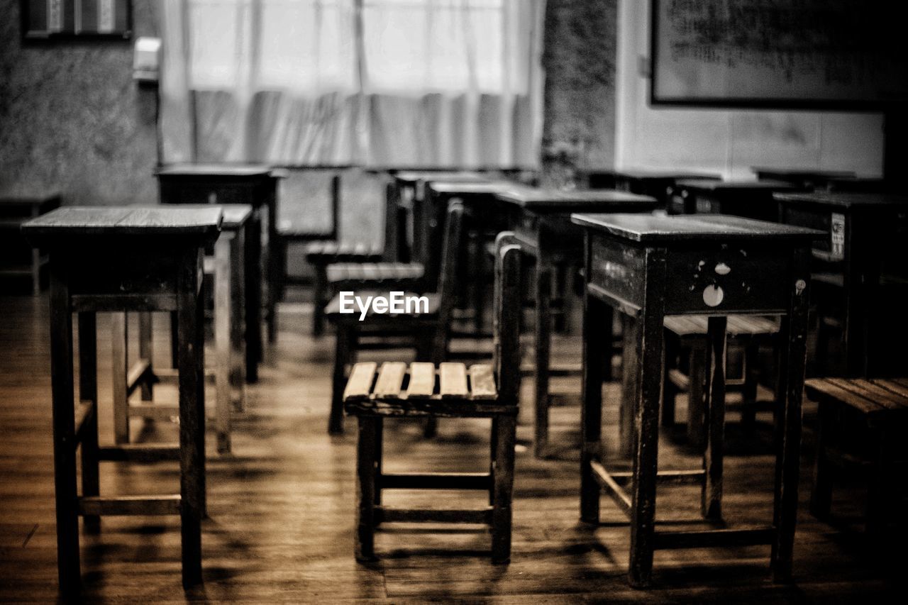 EMPTY CHAIRS AND TABLES IN FRONT OF AN ABANDONED ROOM