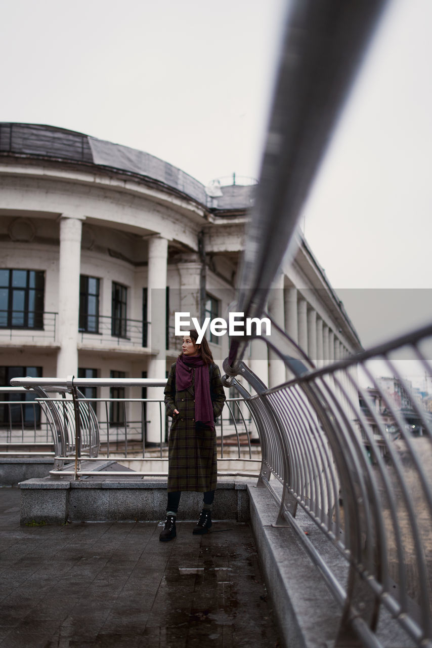 Low angle portrait of confident young woman standing in the city