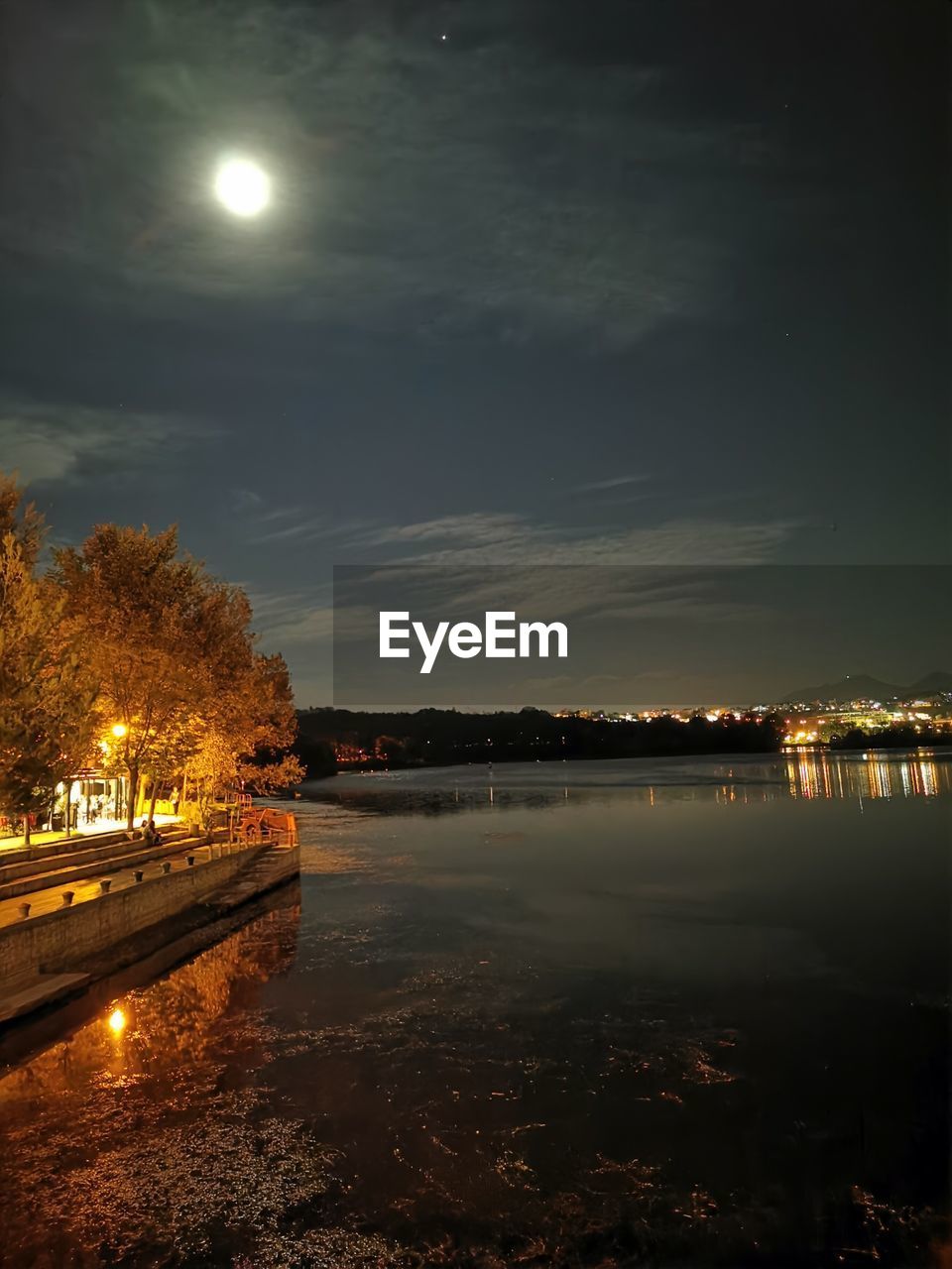 SCENIC VIEW OF ILLUMINATED LAKE AGAINST SKY AT NIGHT