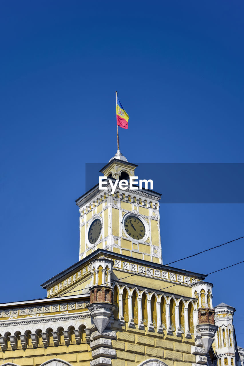 Moldovan flag is fixed on clock tower of old municipality building in chisinau, moldova. copy space.