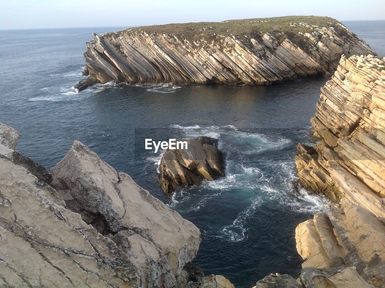 Rock formations by sea against sky