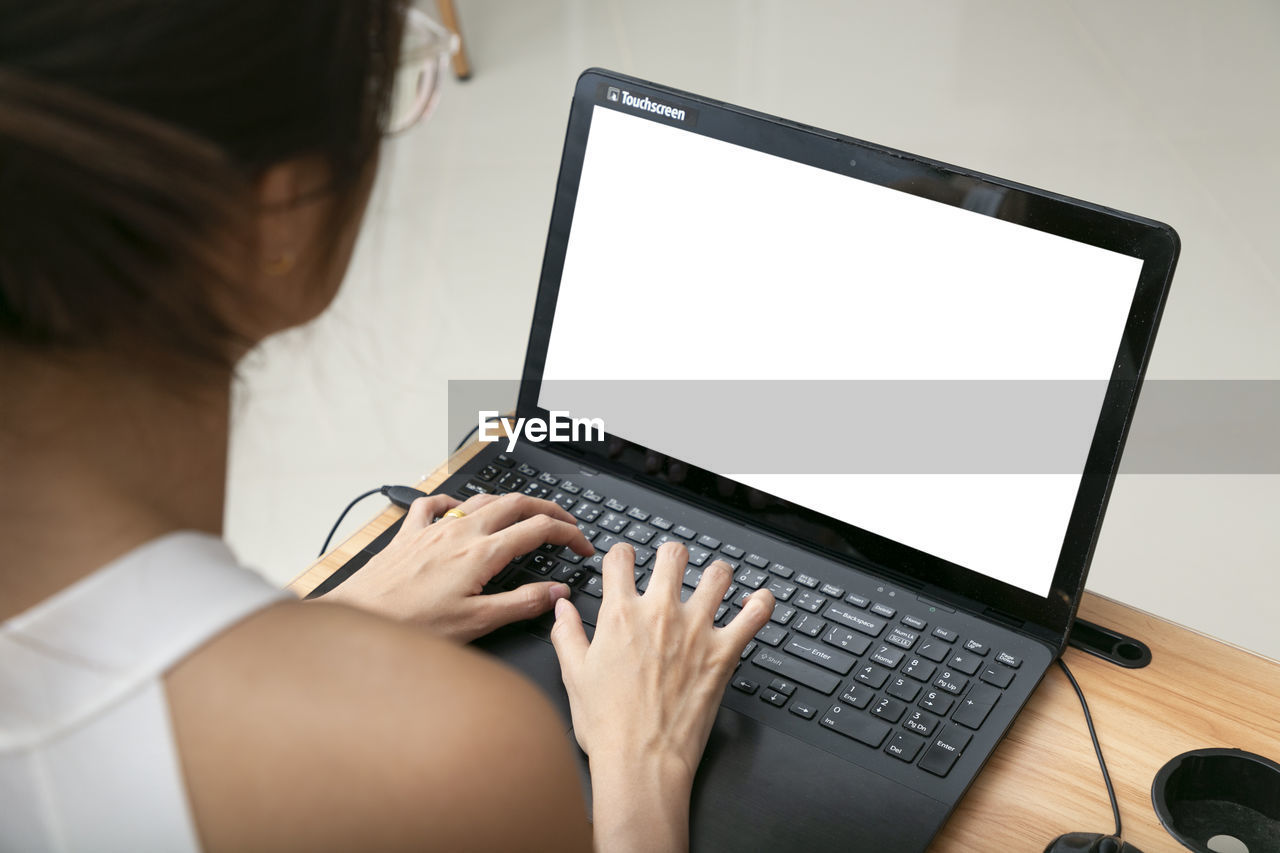 midsection of woman using laptop on table