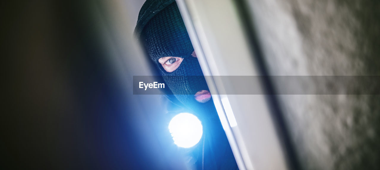 Portrait of thief seen through door