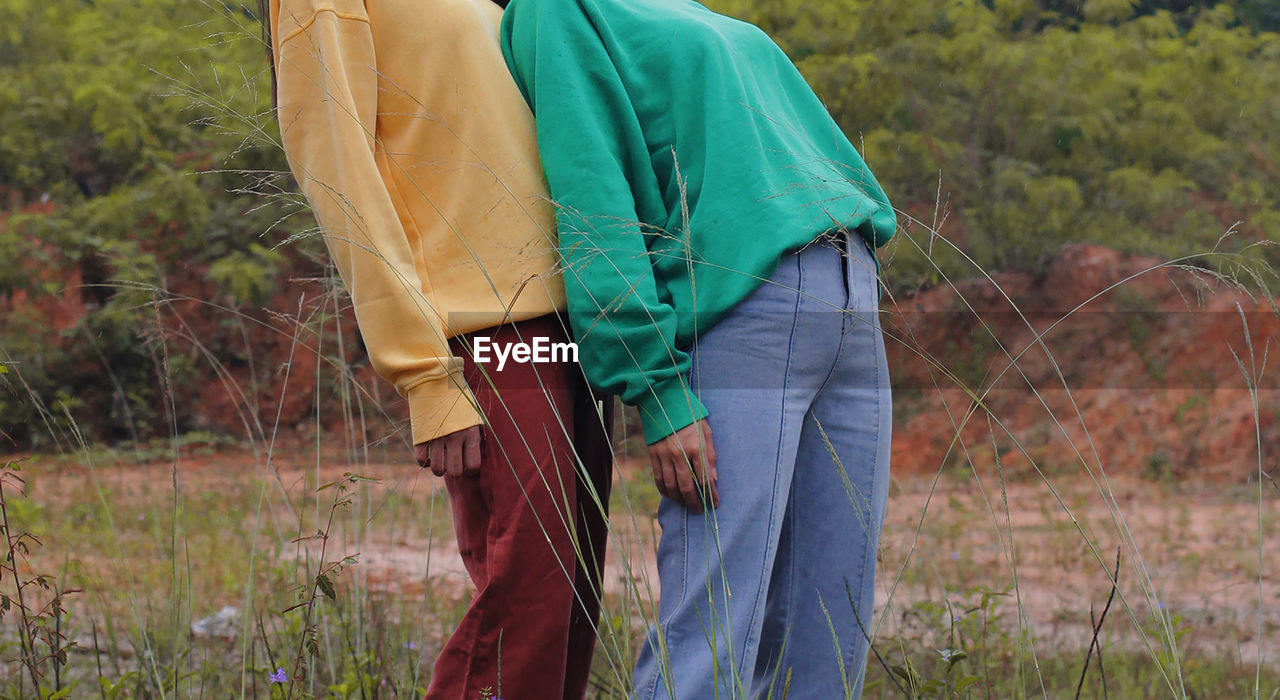 Midsection of couple standing on field