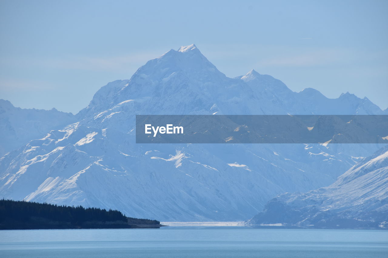 Scenic view of snowcapped mountains by sea against sky