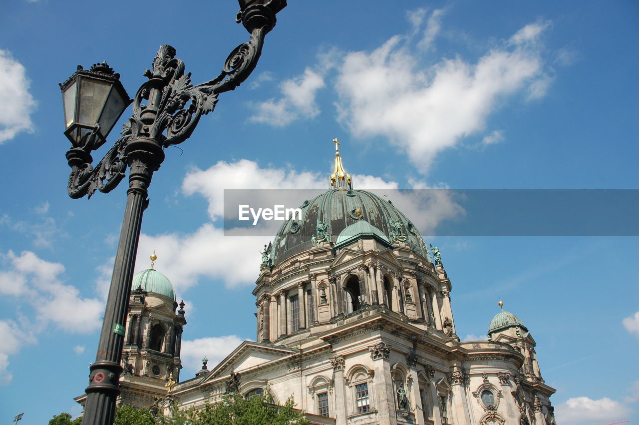 Low angle view of antique gas light by berlin cathedral against sky