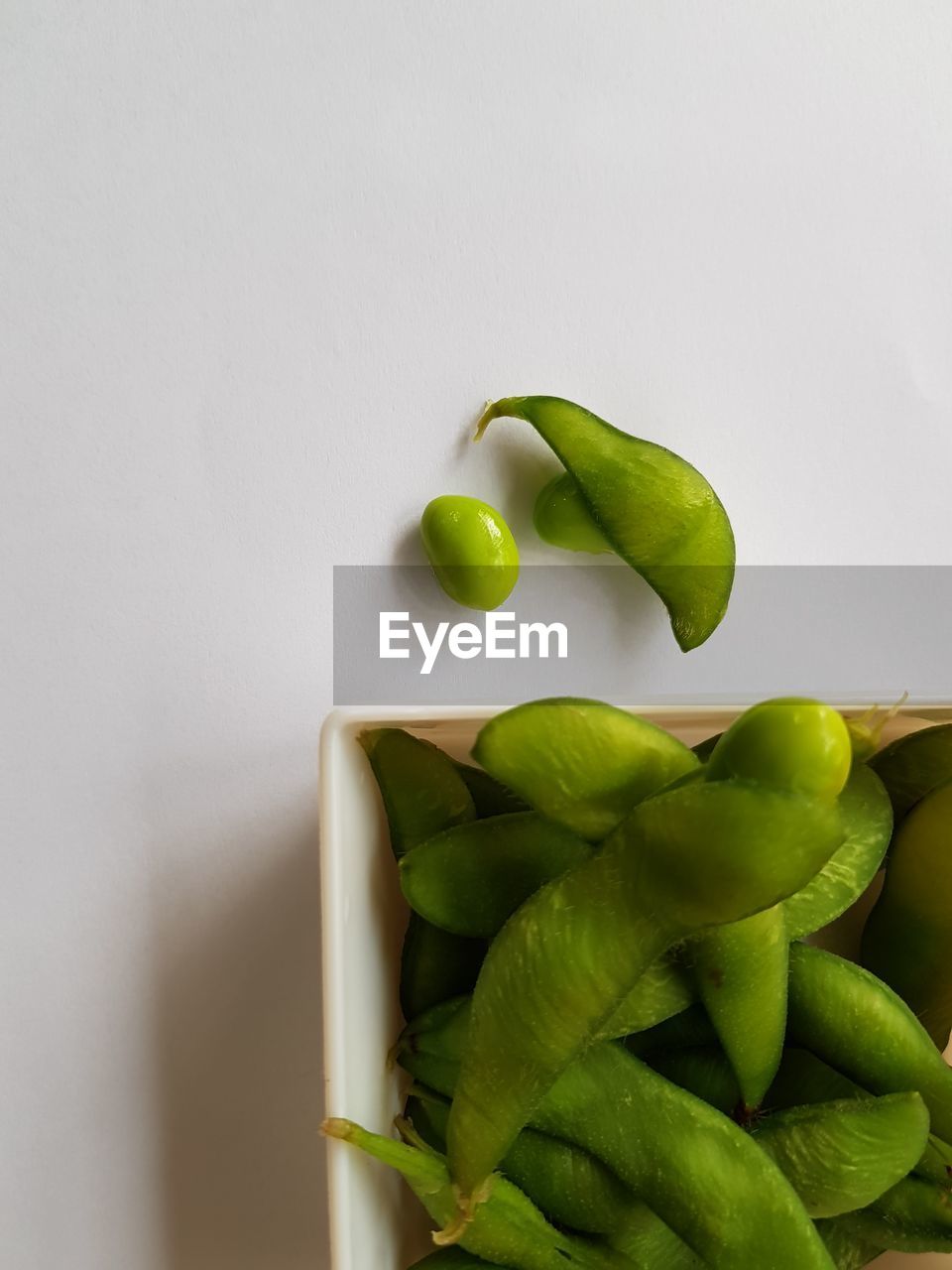 Close-up of green edamame against white background