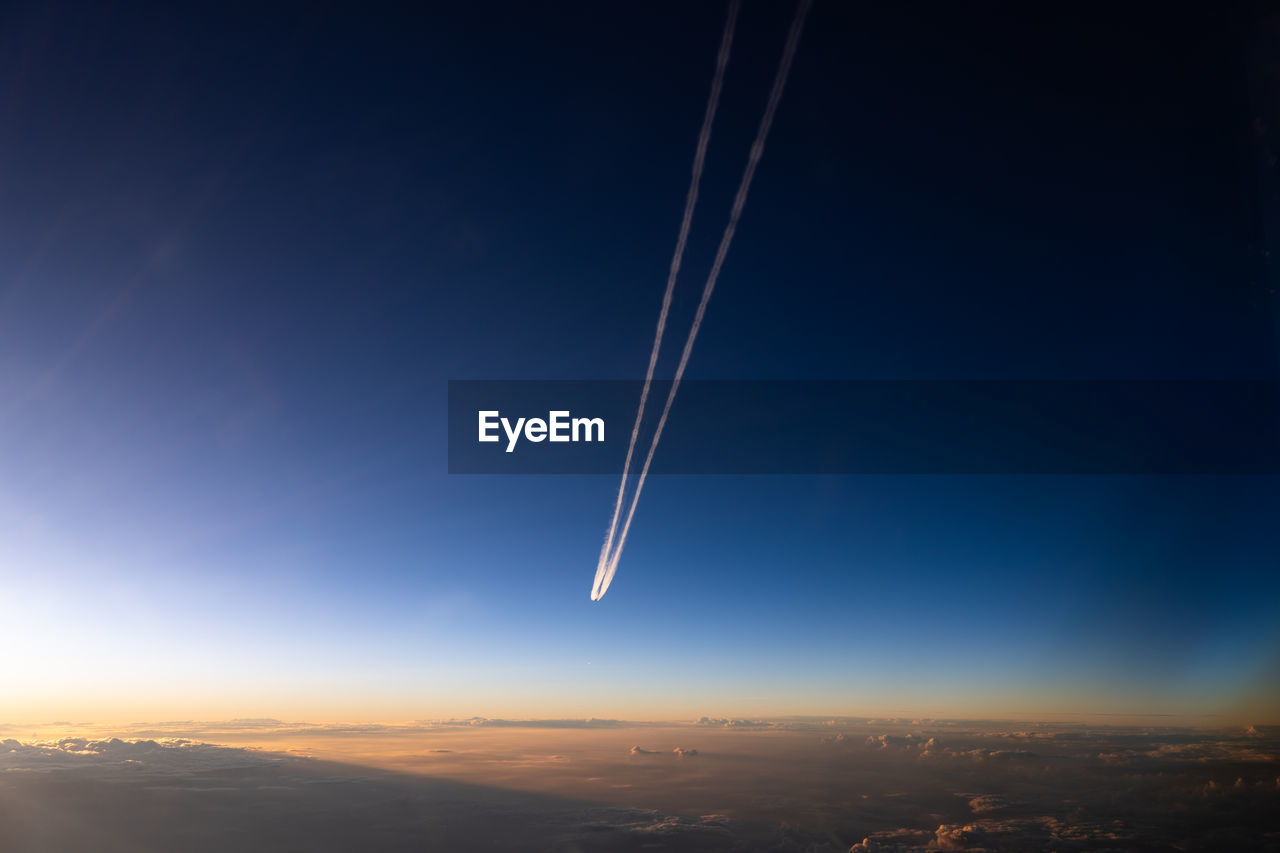 low angle view of airplane wing against sky at sunset