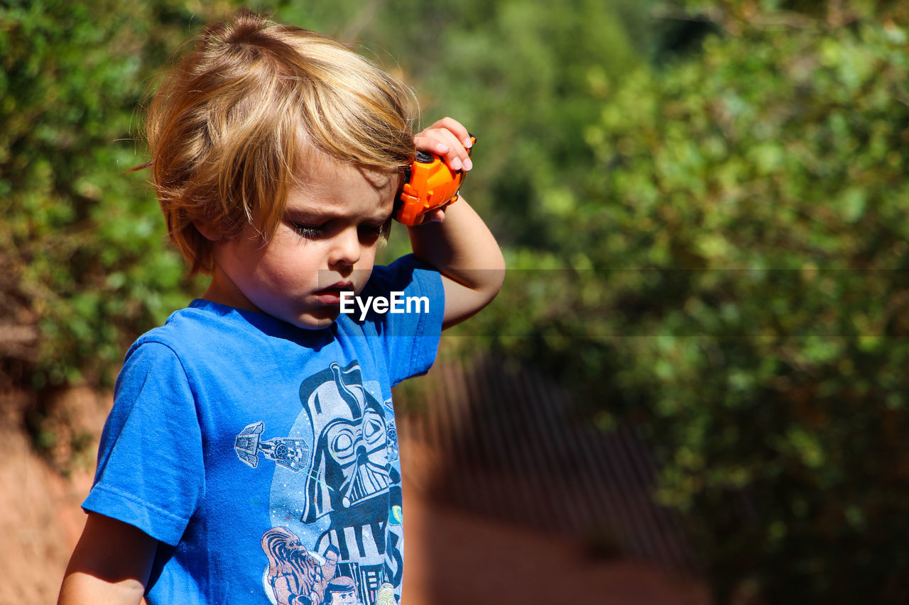 PORTRAIT OF BOY PLAYING WITH TOY