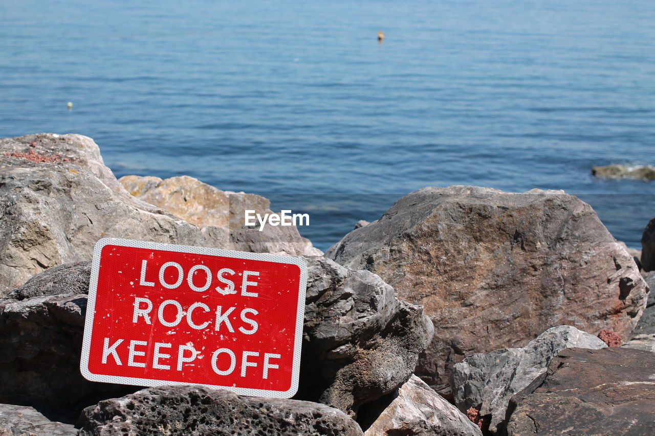 Warning sign on rocks at oddicombe beach