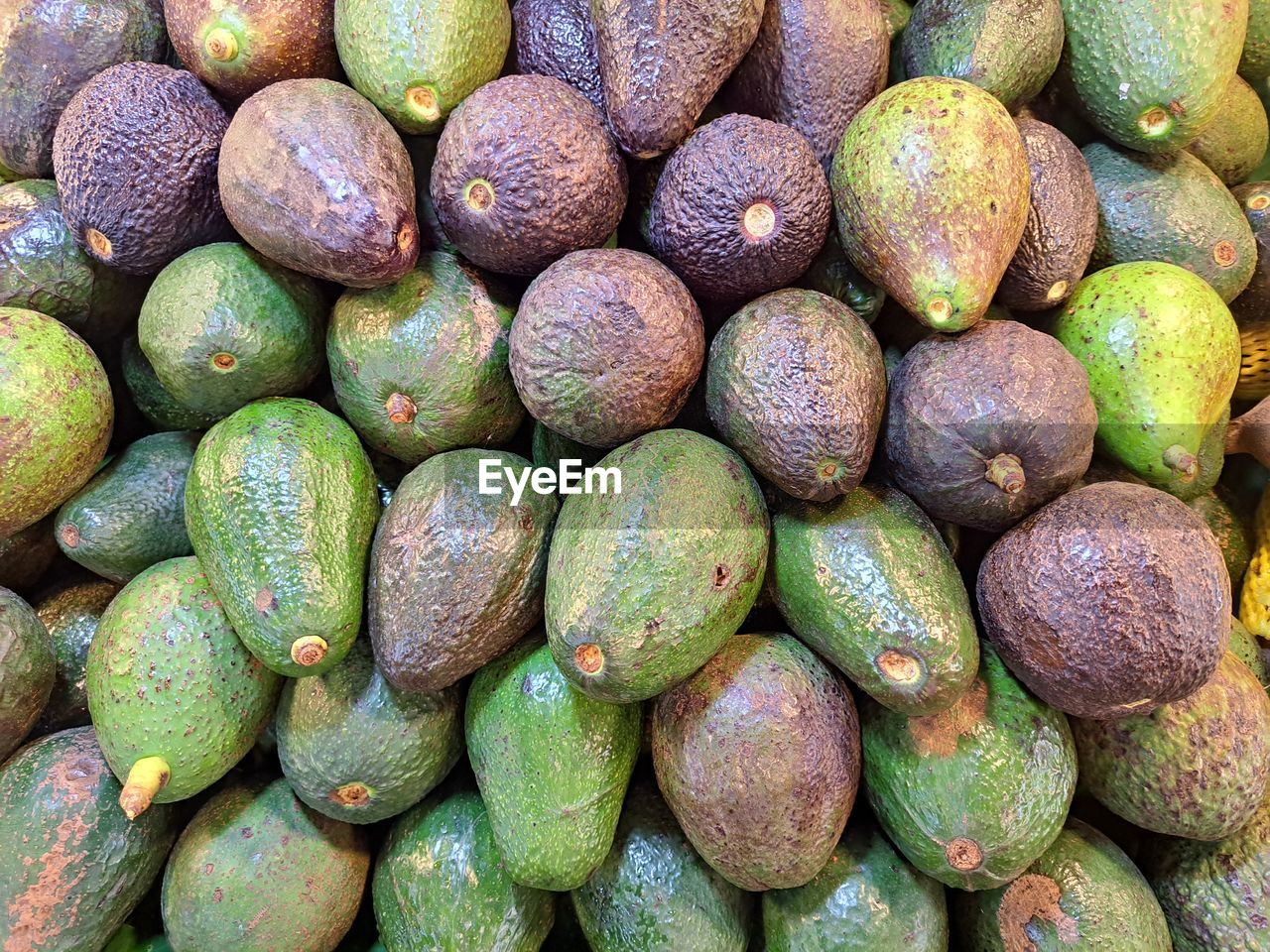 food and drink, food, large group of objects, healthy eating, freshness, full frame, abundance, wellbeing, green, market, backgrounds, produce, no people, fruit, plant, for sale, retail, still life, high angle view, close-up, market stall, day, tropical fruit, avocado, business, directly above, outdoors