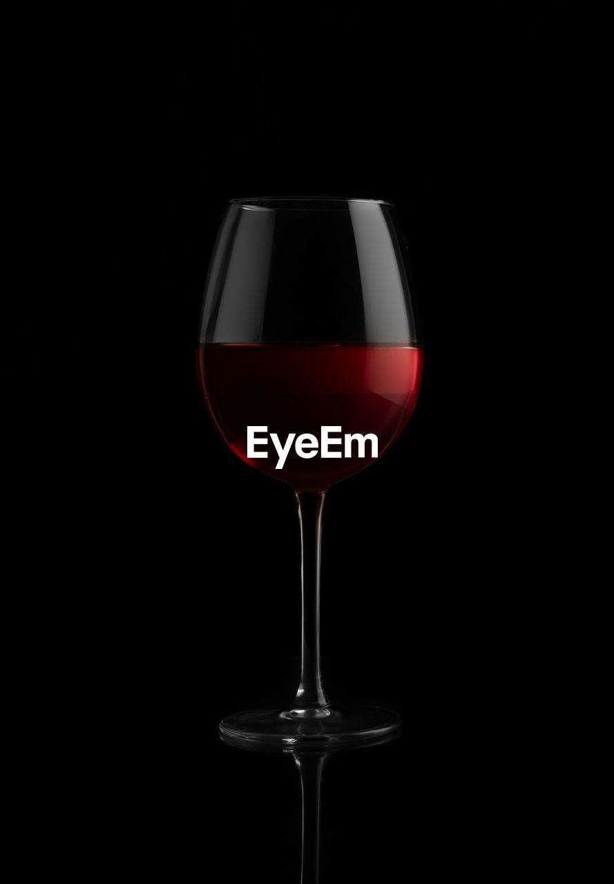 CLOSE-UP OF WINE GLASSES AGAINST BLACK BACKGROUND