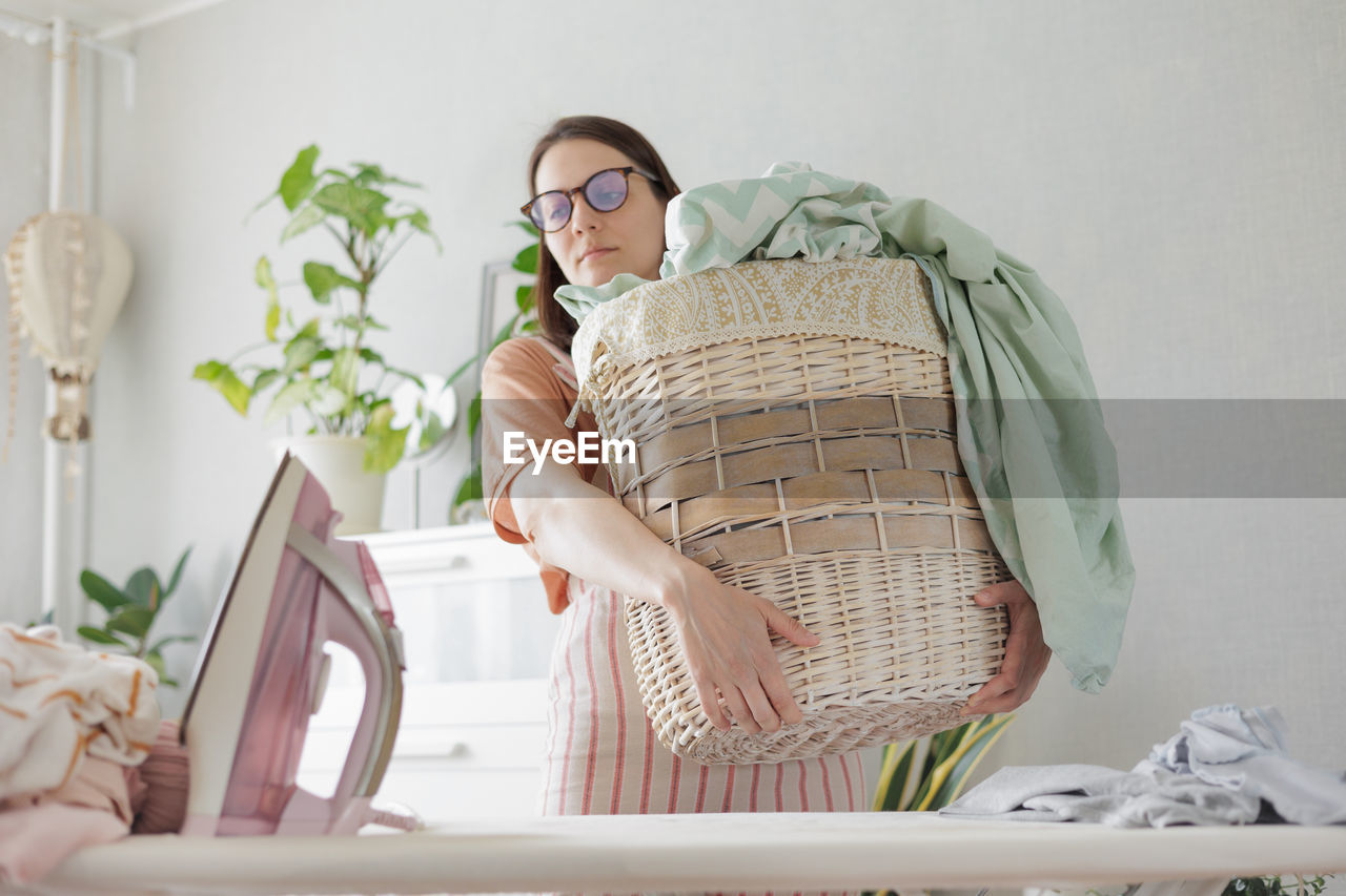 portrait of smiling young woman using digital tablet while sitting on table