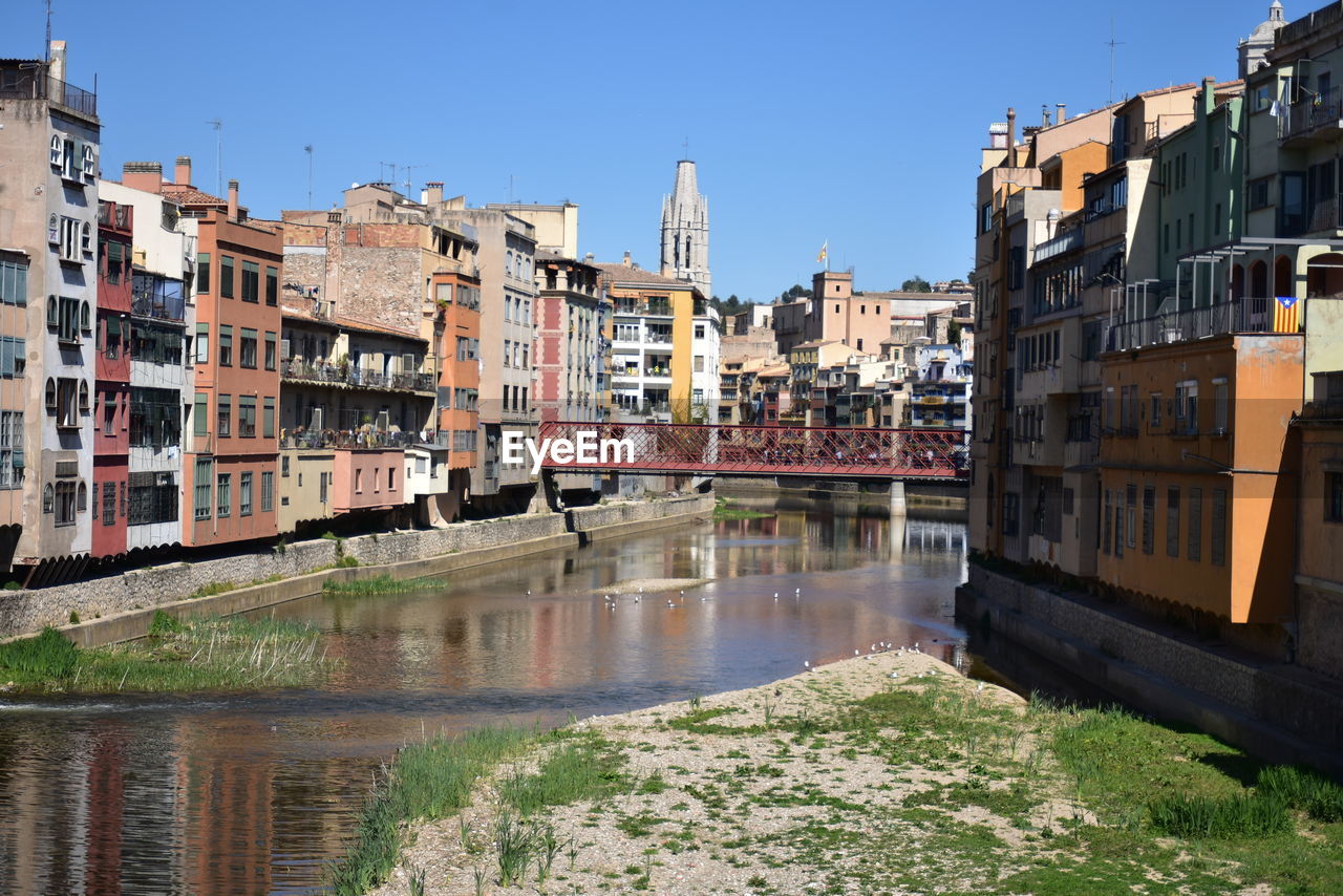 Canal amidst buildings against sky in city