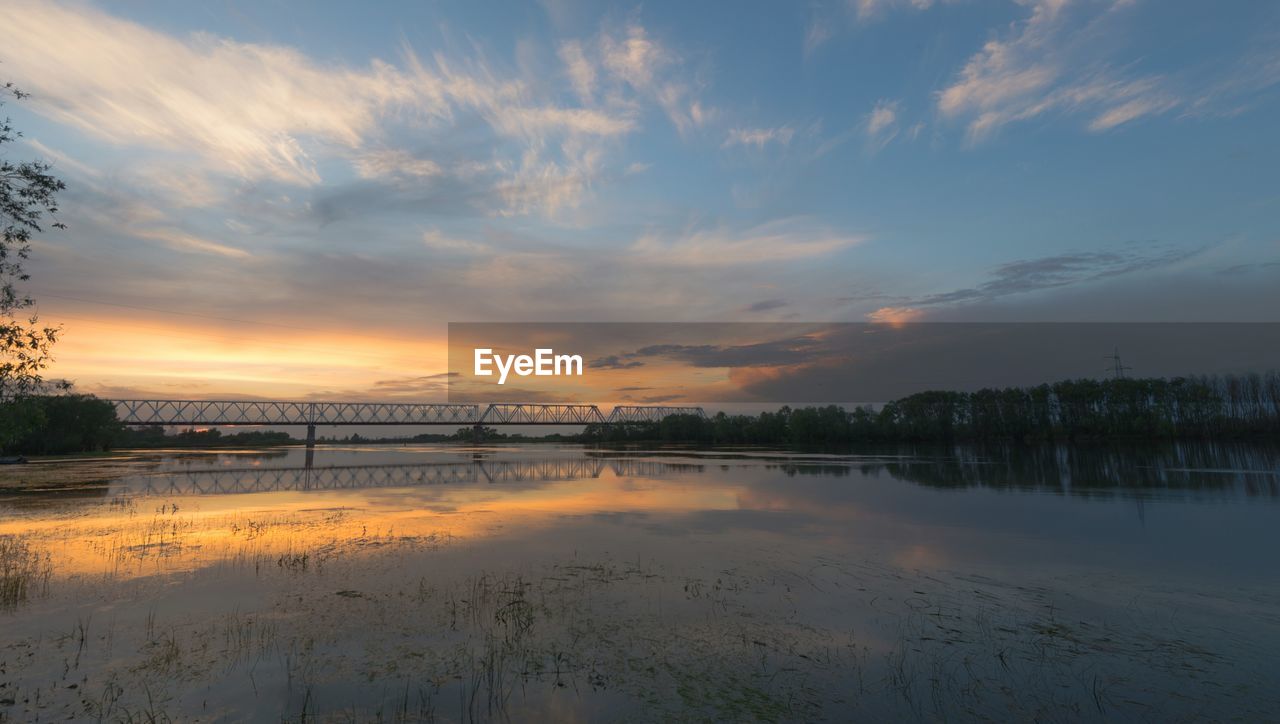 Scenic view of river against sky at sunset