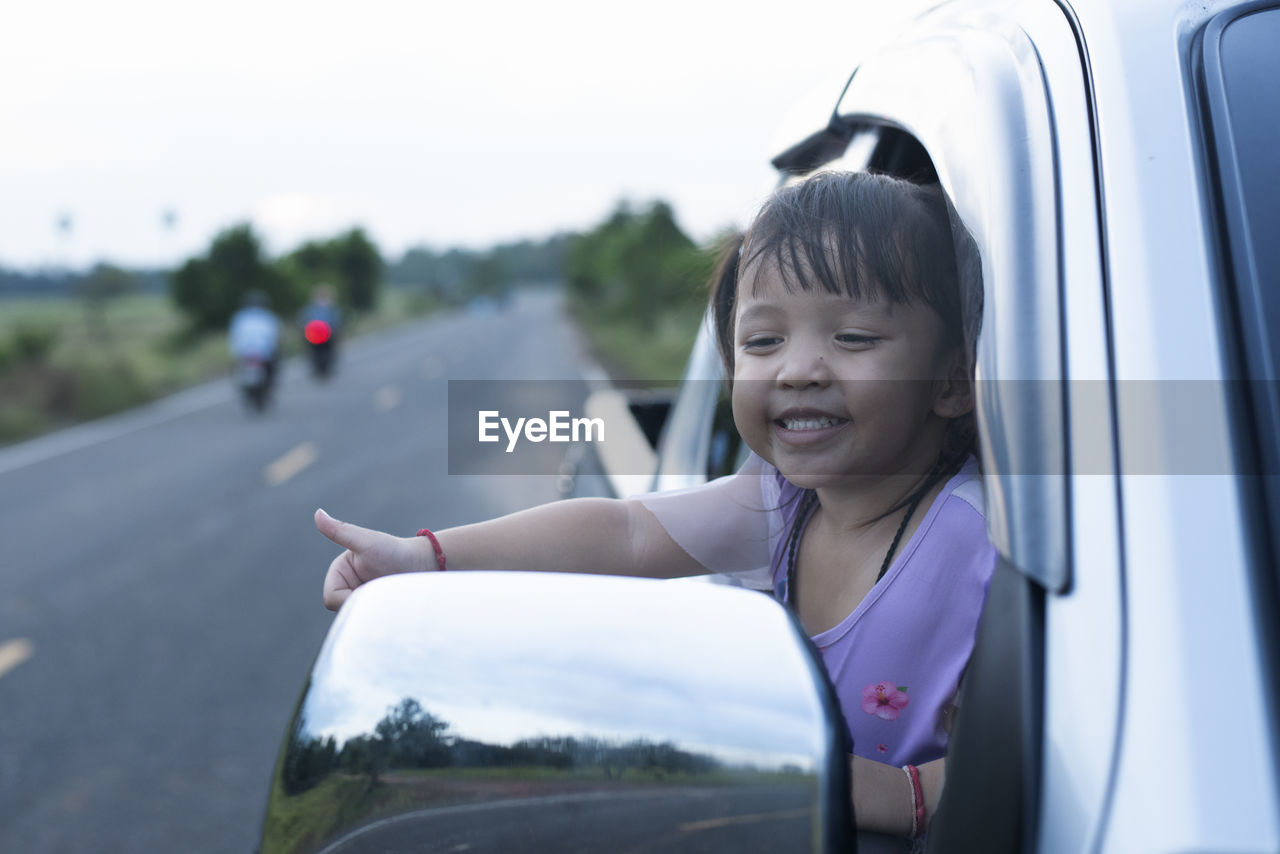 portrait of smiling young woman sitting in car