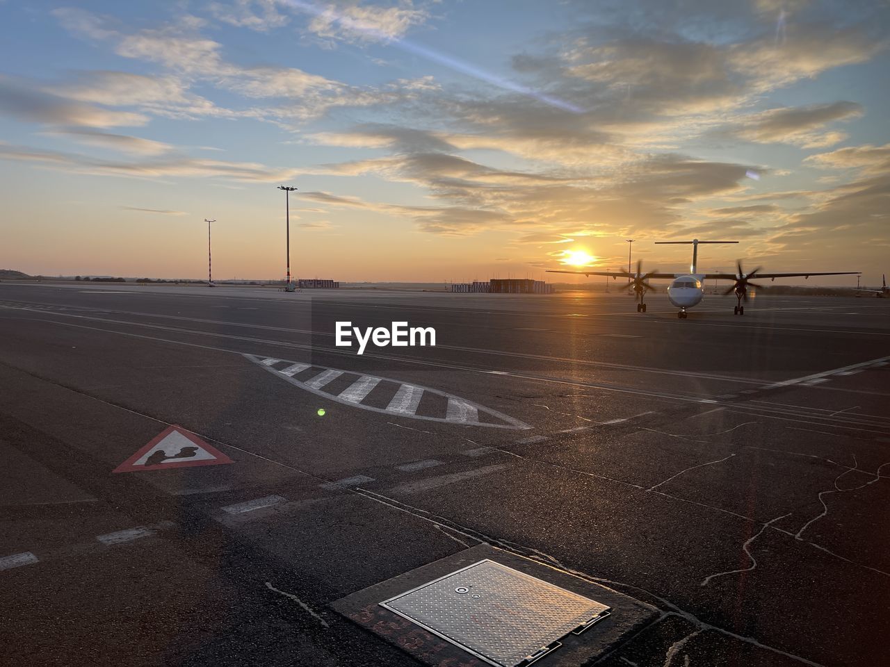 sky, sunset, transportation, cloud, road, nature, horizon, mode of transportation, dusk, sign, airport runway, sunlight, evening, no people, airport, sun, travel, light, symbol, outdoors, environment, marking, road marking, street