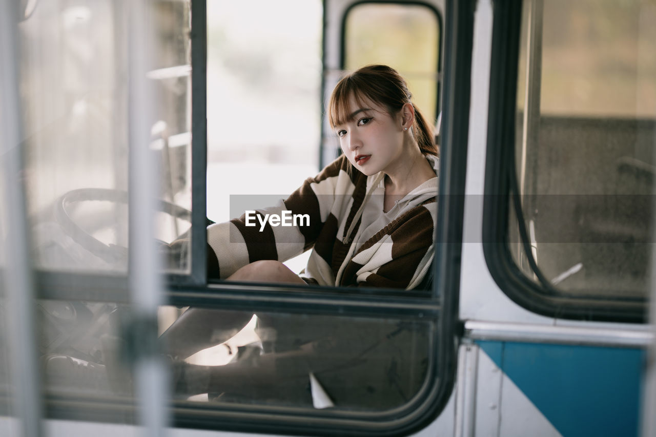 portrait of young woman sitting in bus