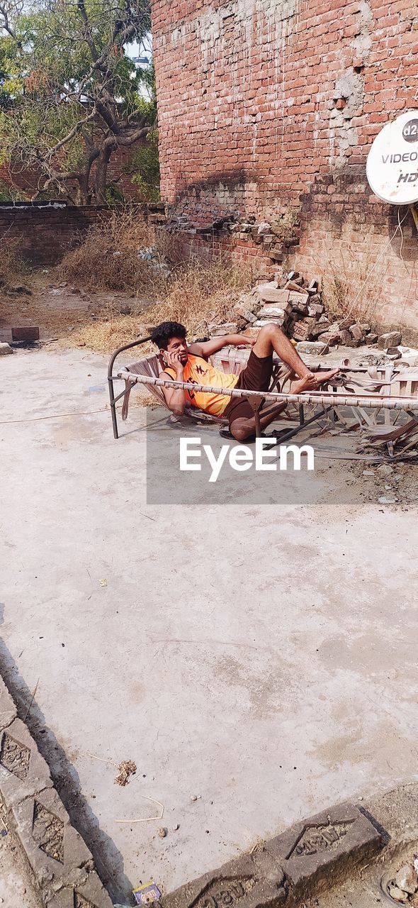 MEN RELAXING ON WALL