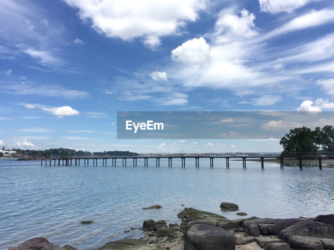 Bridge over river against sky in city