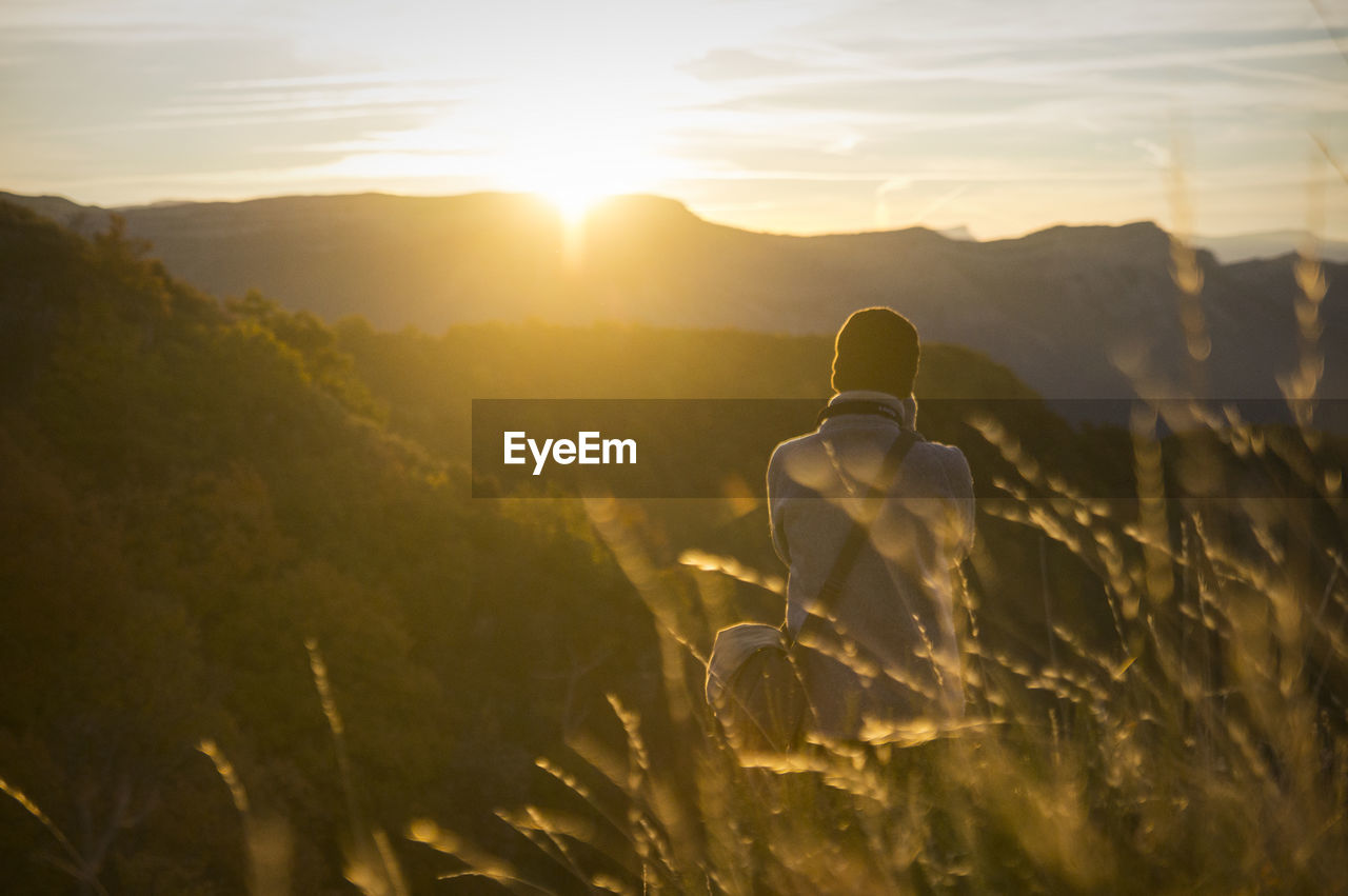 Rear view of man on mountain against sky