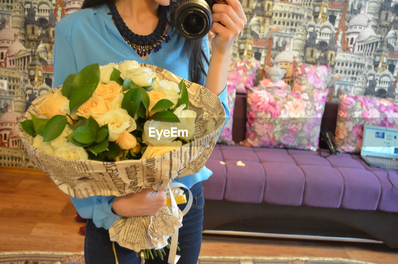 Close-up mid section of a woman holding bouquet