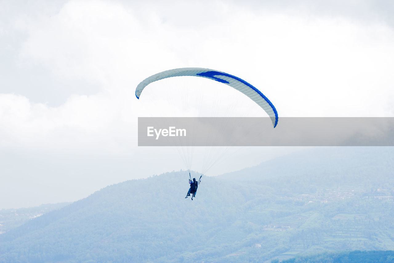 Person paragliding against sky