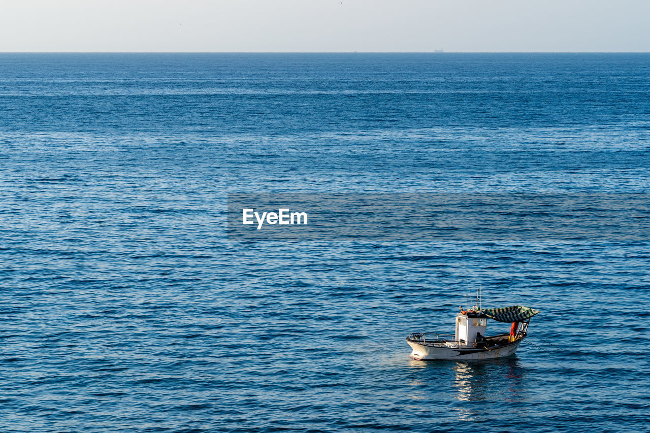 BOAT ON SEA AGAINST SKY