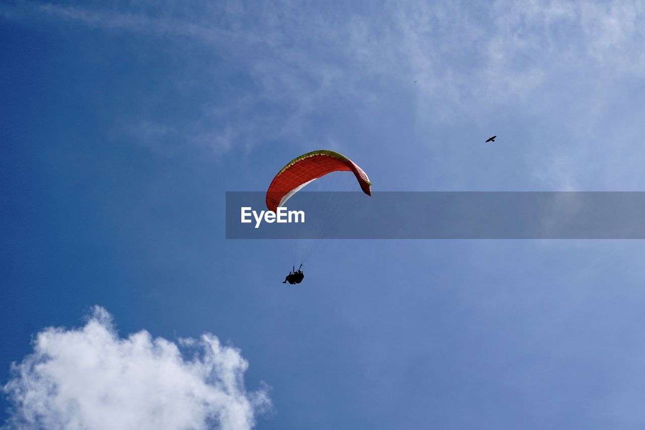 Low angle view of person paragliding against sky