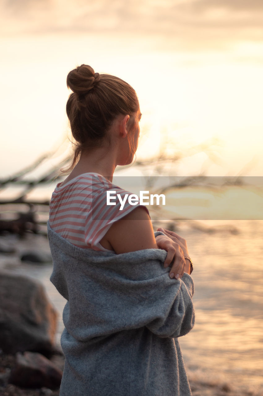 Woman looking at sea during sunset