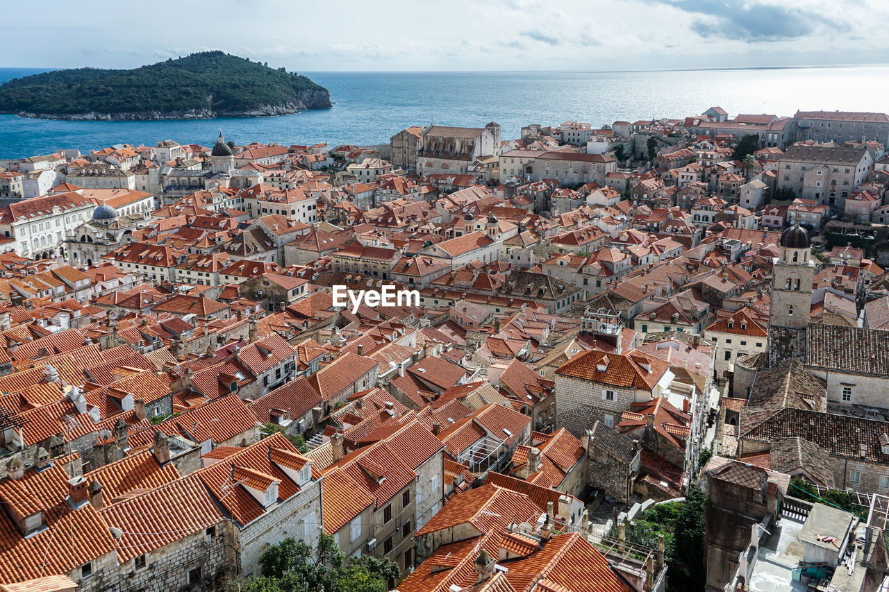 HIGH ANGLE VIEW OF TOWNSCAPE AGAINST SEA