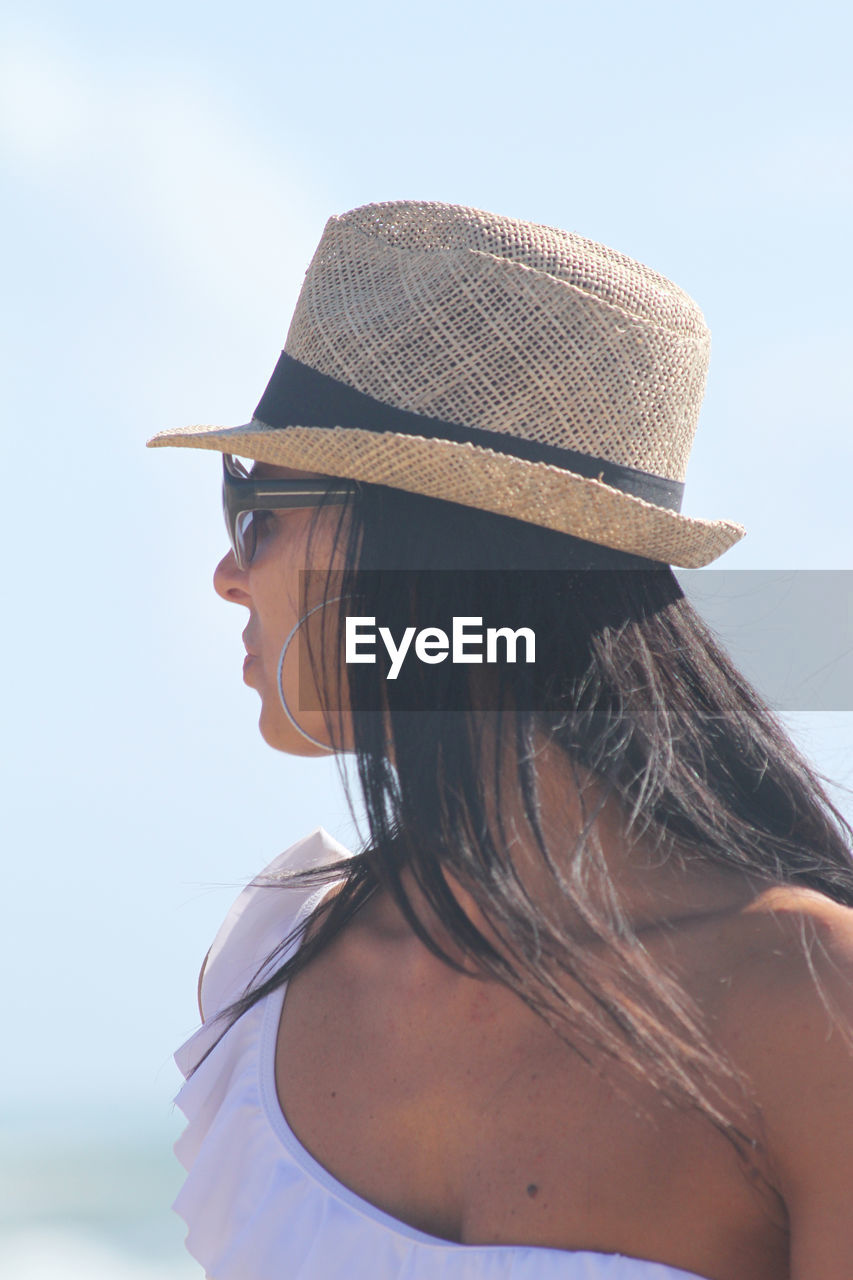 Close-up of mature woman wearing hat while standing against sky during sunny day