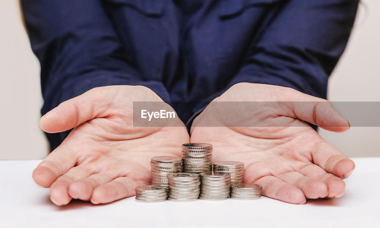 finance, coin, money, savings, business, currency, hand, wealth, cash, investment, person, one person, adult, business finance and industry, retirement, finance and economy, senior adult, corporate business, success, front view, men, banking, clothing, businessman, finger, holding, recession, planning, money handling, achievement, debt, economy, paper currency, indoors, studio shot, occupation, home finances