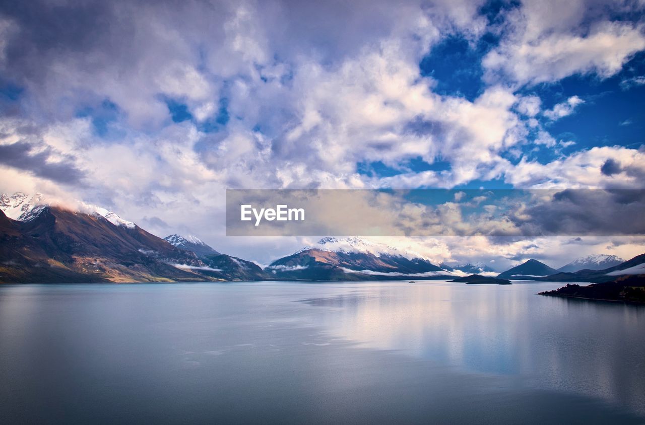 Scenic view of lake and snowcapped mountains against sky