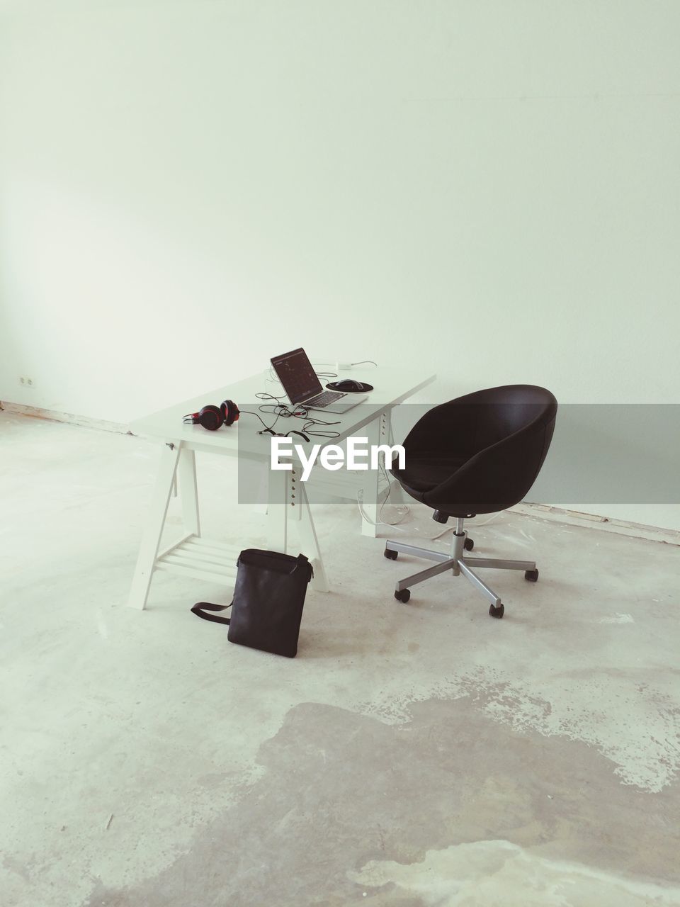 High angle view of laptop and headphones on desk in workshop