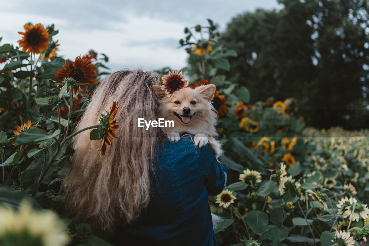 Young woman with dog by plants