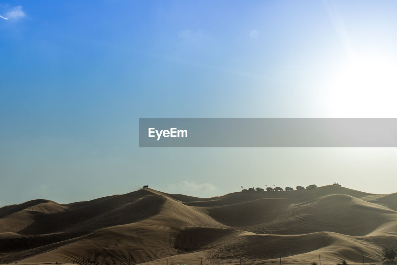 Sand dunes in desert against sky