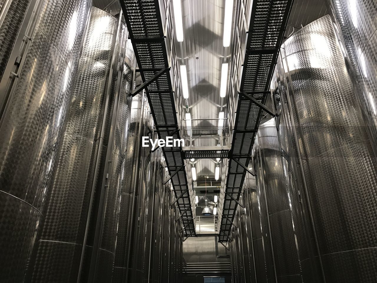 Low angle view of illuminated staircase in building / big tanks for vine storage 