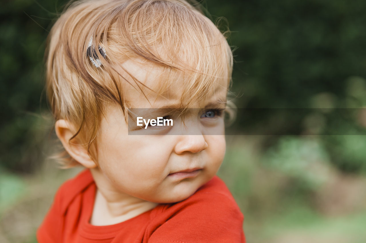 Close-up of cute boy girl looking away while sitting outdoors