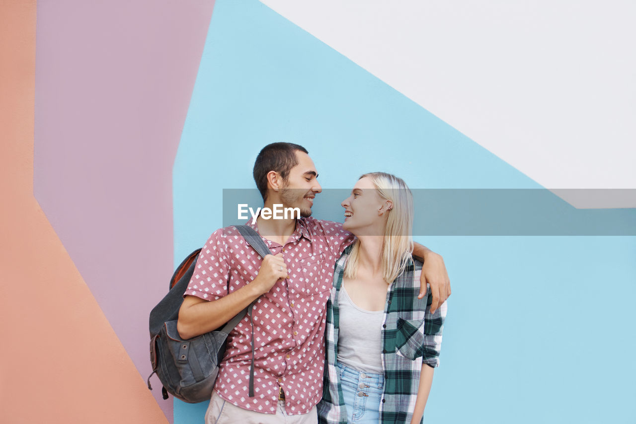 Smiling couple against wall