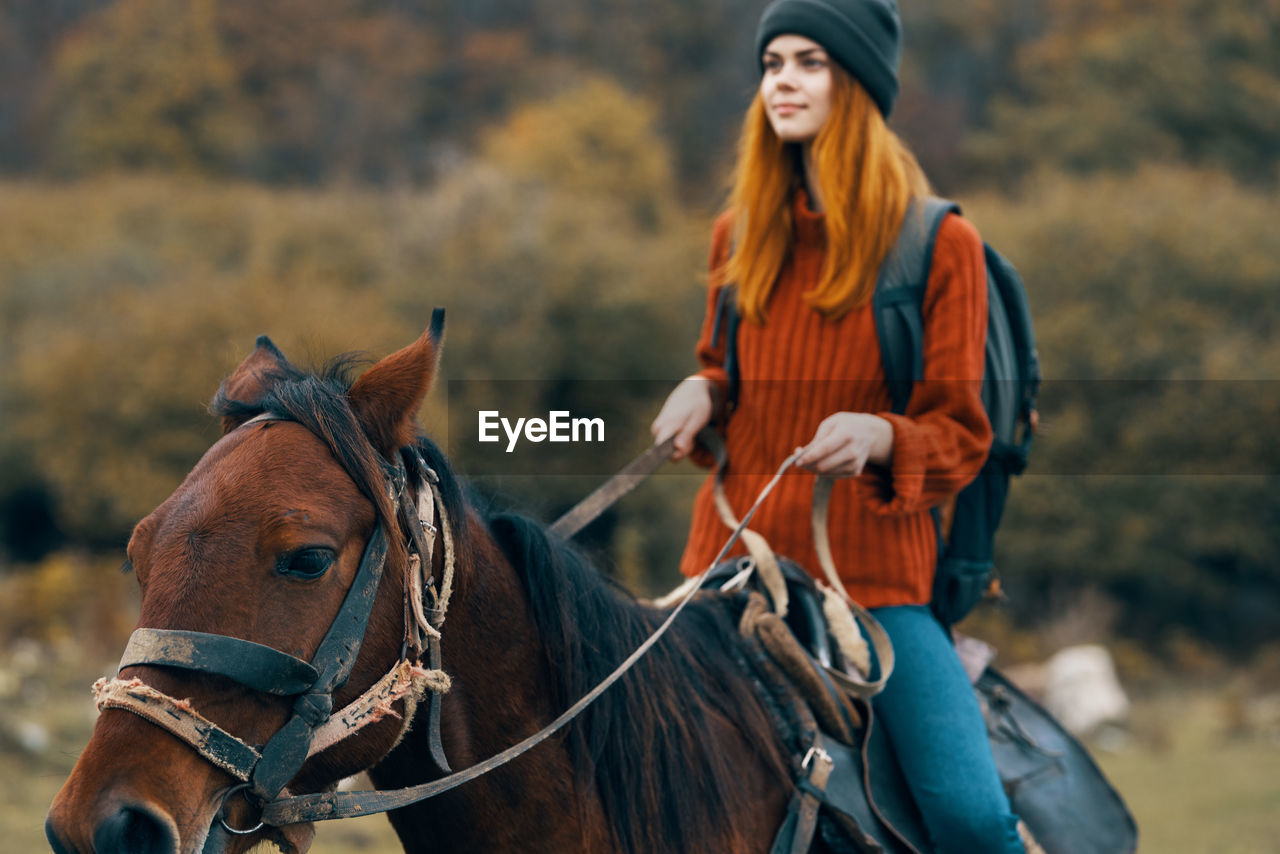 BEAUTIFUL YOUNG WOMAN RIDING A HORSE