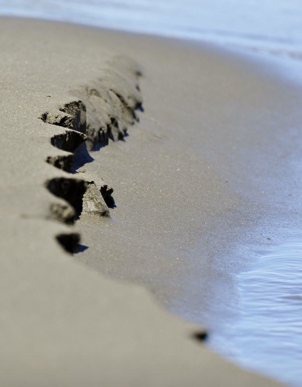 High angle view of wet sand at shore